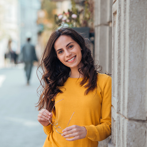 A young woman in a yellow dress smiling